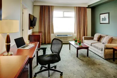 a hotel room with a desk and a chair and a couch at Chateau Nova Yellowhead in Edmonton