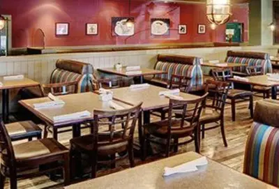 a restaurant with tables and chairs in a room at Chateau Nova Kingsway in Edmonton