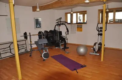 a gym with weights and exercise equipment on a wooden floor at Williston Lake Resort in Hudson Hope