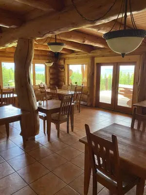 a dining room with wooden tables and chairs at Williston Lake Resort in Hudson Hope