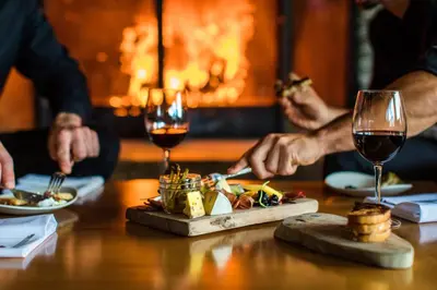 a group of people sitting at a table with food and wine at The Juniper Hotel & Bistro in Banff