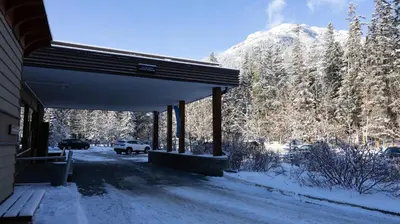 a snow covered building with a view of a mountain at The Juniper Hotel & Bistro in Banff