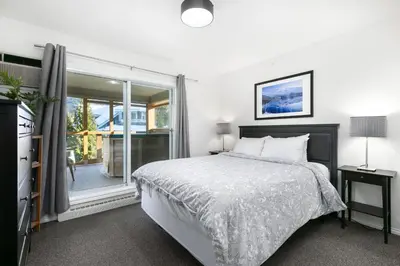 a bedroom with a bed and a large window at Glaciers Reach by Allseason Vacation Rentals in Whistler