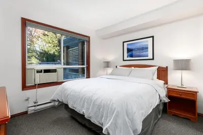 a bedroom with a large bed and a window at Glaciers Reach by Allseason Vacation Rentals in Whistler