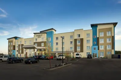 a parking lot with cars parked in front of a building at TownePlace Suites by Marriott Edmonton Sherwood Park in Sherwood Park