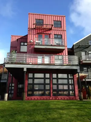 a red building with a balcony on the side of it at Island Village Properties at Fred Tibbs in Tofino