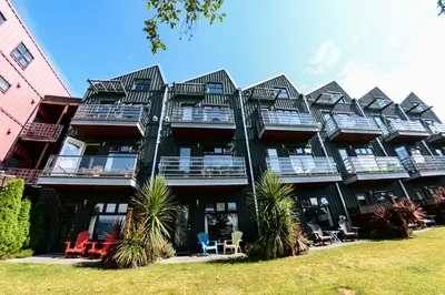 a large green building with a lot of windows at Island Village Properties at Fred Tibbs in Tofino