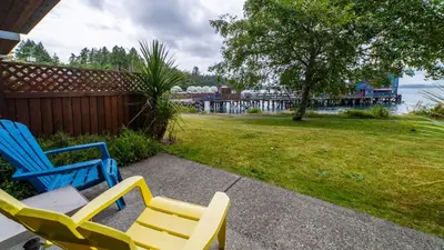 two blue and yellow chairs in a yard with a train at Island Village Properties at Fred Tibbs in Tofino