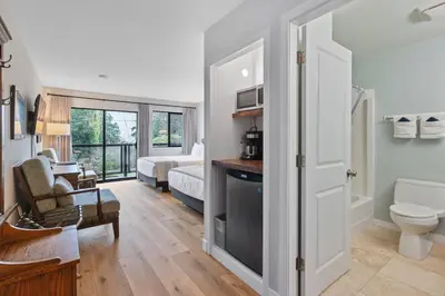 a living room with a toilet and a bedroom at Tofino Motel Harbourview in Tofino