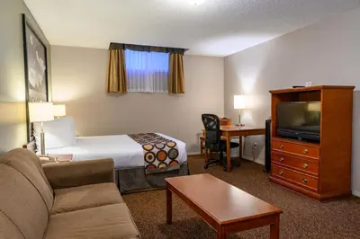 a hotel room with a bed and a tv at Super 8 by Wyndham Cochrane in Cochrane