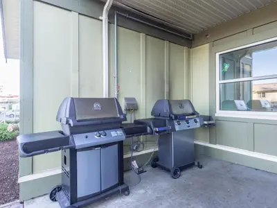 two grilling stations are sitting outside of a building at Vancouver Island Residences in Nanaimo