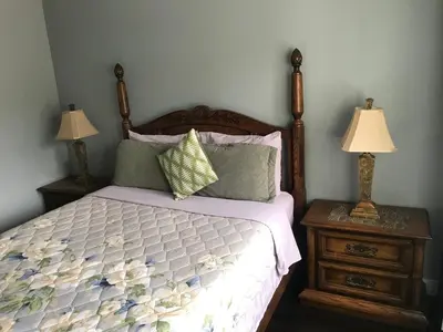 a bedroom with a bed and two night stands with lamps at Lake and Bridge View Vacation Home in West Kelowna