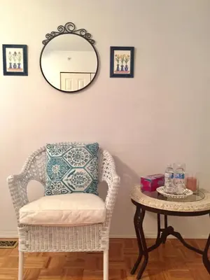 a room with a chair and a table with a mirror at Lee home in Vancouver