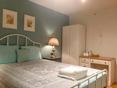 a bedroom with a large bed with blue walls at Lee home in Vancouver
