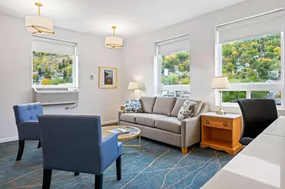 a living room with a couch and chairs and two windows at Crown Columbia Hotel; BW Premier Collection in Trail