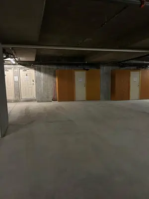 an empty parking garage with white doors and concrete floors at 3 BR 3 Bath ski in ski out with private hot tub in Big White