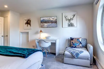 a bedroom with a bed and a desk and a chair at THE LOOKOUT PENTHOUSE // a luxe suite in Whistler in Whistler
