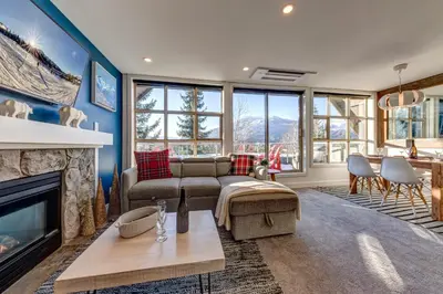 a living room with a couch and a fireplace at THE LOOKOUT PENTHOUSE // a luxe suite in Whistler in Whistler
