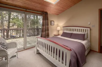 a bedroom with a bed and a balcony at Falcon Cabin in Fairmont Hot Springs