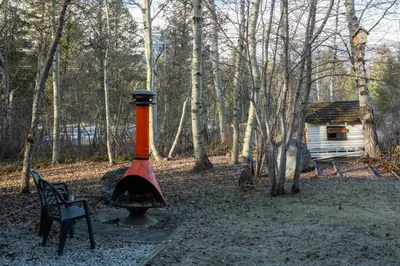 an orange and black object next to a bench and a house at Creekside Cabin in Fairmont Hot Springs