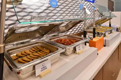 a buffet line with trays of food on a counter at Wingate by Wyndham Fort Saskatchewan in Fort Saskatchewan