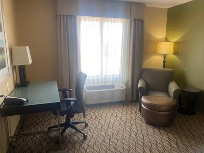 a hotel room with a desk and chair and a window at Wingate by Wyndham Fort Saskatchewan in Fort Saskatchewan