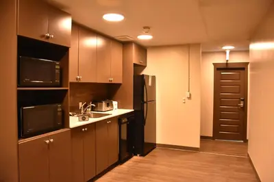 a small kitchen with a sink and a microwave at PARTY HOSTEL - The Canmore Hotel Hostel in Canmore