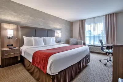a hotel room with a large bed and a desk at Comfort Inn & Suites South in Calgary