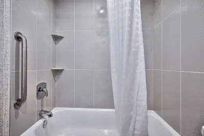 a bathroom with a shower with a white shower curtain at Comfort Inn & Suites South in Calgary