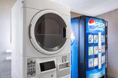 a microwave oven next to a pepsi machine at Travelodge by Wyndham Fort St John in Fort Saint John