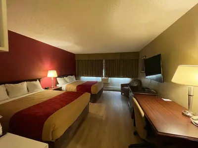 a hotel room with two beds and a television at Travelodge by Wyndham Fort St John in Fort Saint John