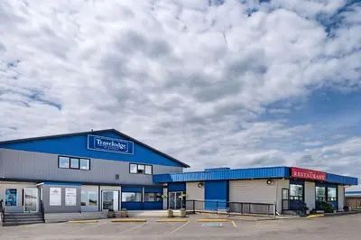a store with a blue building and a cloudy sky at Travelodge by Wyndham Fort St John in Fort Saint John
