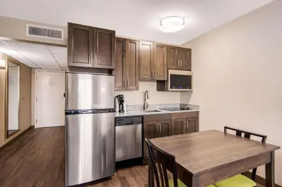 a kitchen with a table and a stainless steel refrigerator at Comfort Inn & Suites in Red Deer