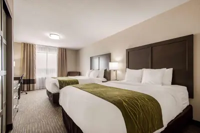 a hotel room with two beds and a window at Comfort Inn & Suites in Red Deer