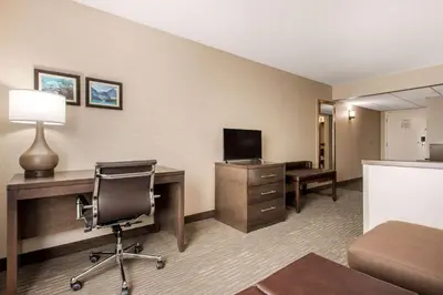a hotel room with a desk and a chair at Comfort Inn & Suites in Red Deer