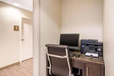 an office with a desk with a computer and a printer at Comfort Inn & Suites in Red Deer