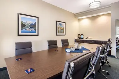 a conference room with a large table and chairs at Comfort Inn & Suites in Red Deer