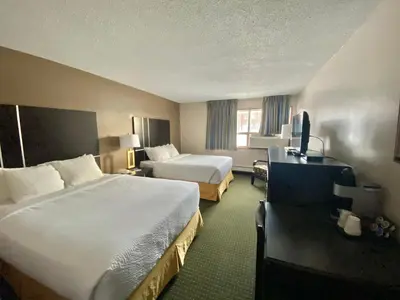 a hotel room with two beds and a television at Ramada by Wyndham Whitecourt in Whitecourt