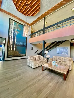 a lobby with couches and a staircase in a building at Ramada by Wyndham Whitecourt in Whitecourt