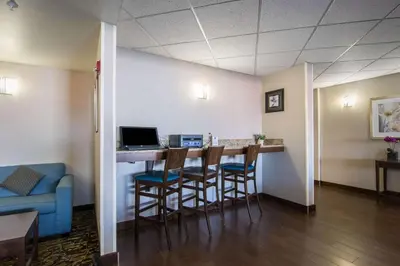 a bar in a waiting room with chairs and a laptop at Comfort Inn & Suites Airport South in Calgary