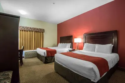 two beds in a hotel room with red walls at Comfort Inn & Suites Airport South in Calgary