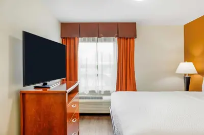 a bedroom with a bed and a flat screen tv at Days Inn & Suites by Wyndham Sherwood Park Edmonton in Sherwood Park