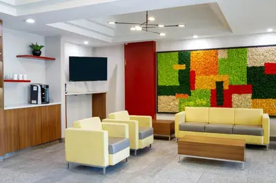 a waiting room with yellow chairs and a colorful wall at Days Inn & Suites by Wyndham Sherwood Park Edmonton in Sherwood Park