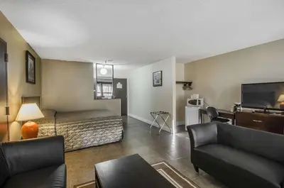 a room with a bed and a couch and a tv at Econo Lodge Lloydminster in Lloydminster