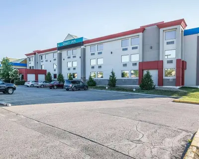a large building with cars parked in a parking lot at Quality Inn & Conference Centre in Red Deer