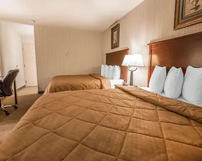 a hotel room with two beds and a chair at Quality Inn & Conference Centre in Red Deer