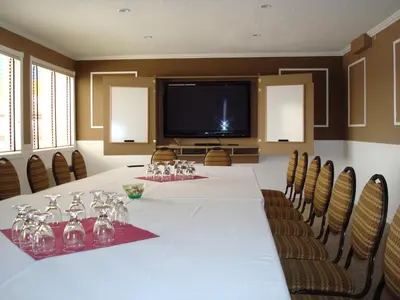 a conference room with a long table with chairs and a television at Quality Inn & Conference Centre in Red Deer