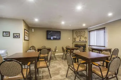 a dining room with tables and chairs and a flat screen tv at Econo Lodge Inn & Suites High Level in High Level