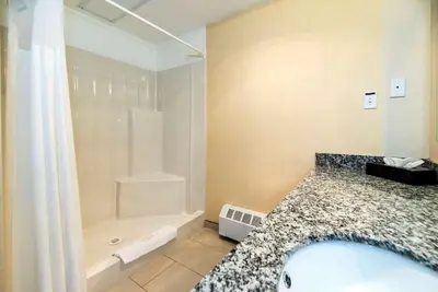 a bathroom with a shower and a bath tub at Prestige Riverside Lodge Quesnel in Quesnel