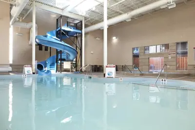 a swimming pool with a blue slide in a building at Sundance Suite - Beautiful Condo With Open Pool And Hot Tub in Canmore
